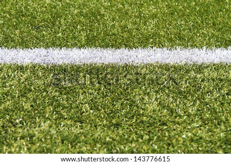 White stripe on a bright green artificial grass soccer field