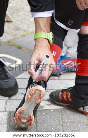 Rotterdam; The Netherlands-June 16; 2013: Youth player leaving the training field in Feyenoord after a football training session for children has his soccer boot signed by Ex-profvoetballer Kevin Vink