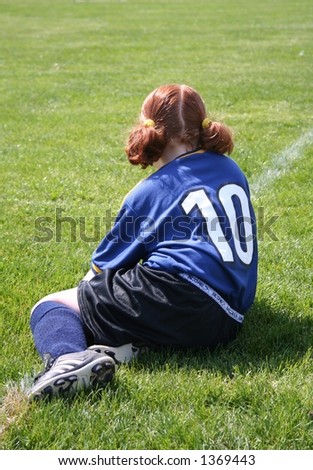 Young girl in soccer uniform waiting for a goal