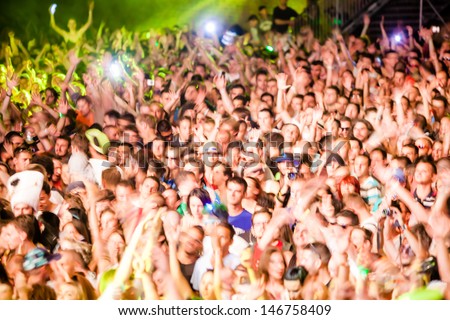 NOVI SAD, SERBIA - JULY 11: Audience in front of the Dance Arena at EXIT 2013 Music Festival, during Fat Boy Slim\'s performance on July 11, 2013 in the Petrovaradin Fortress in Novi Sad. (motion blur)