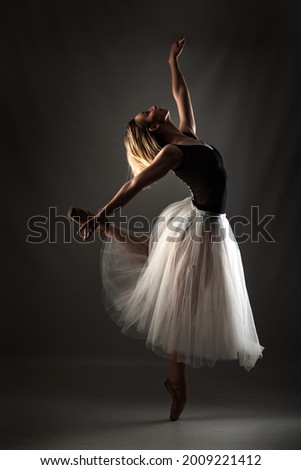 ballerina with a white dress and black top posing on gray background Stockfoto © 