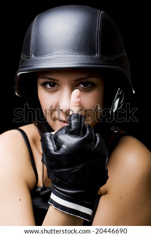 portrait of a beautiful girl with US Army-style motorcycle helmet, and gloves, showing middle finger