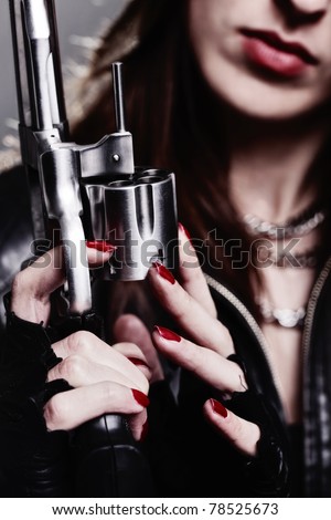 rebel girl with motorcycle gloves holding a revolver