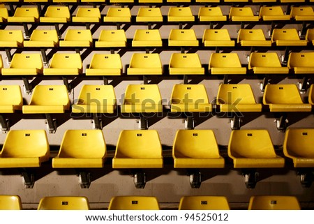 many yellow chairs with harsh light from side