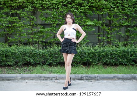 Beautiful Teenage Model girl Dressed in Casual Short Dress on green leaf