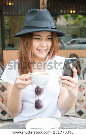 woman drinking coffee  at coffee shop and play mobile phone(soft