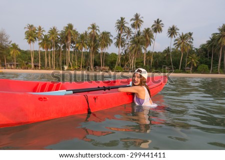 Young lady with the kayak in a tropical lagoon at sunny day