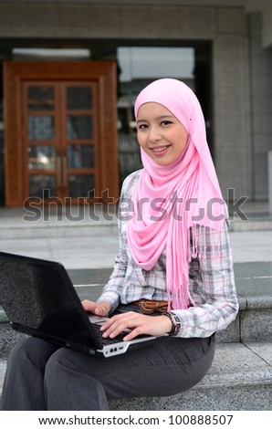 Closeup portrait of a pretty young muslim woman with notebook
