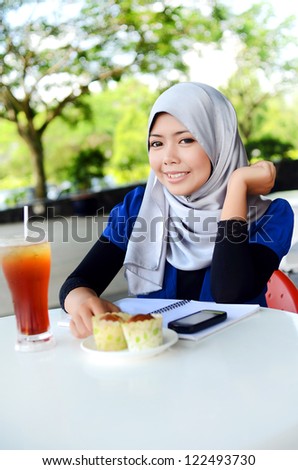 Young asian muslim woman in head scarf smile and study