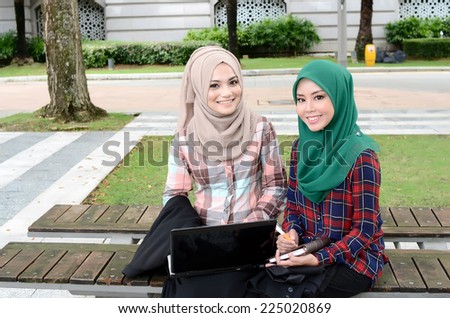 Young asian muslim woman in head scarf smile at park together