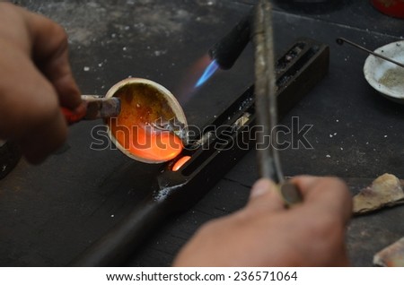Jeweler melting gold with gasoline burner