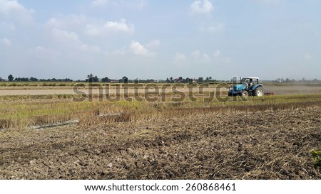 Kuala Selangor, Malaysia - Feb 15 , 2015: Tractor plowing a rice field at Kuala Selangor, Malaysia on February 15, 2015