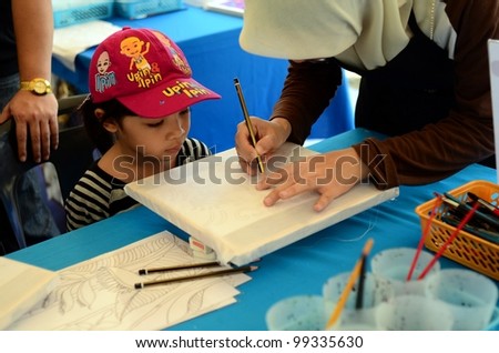PUTRAJAYA, MALAYSIA-FEBRUARY 26: An unidentified student participates in sketches for batik contest with design by Kraf Selangor during WOW Putrajaya Carnival on February 26,2012 in Putrajaya