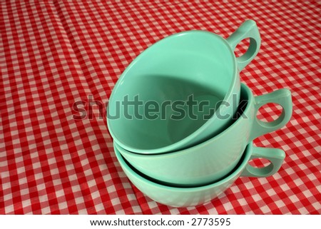 three cups stacked over a red checkered background