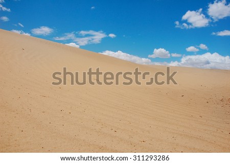 Desert scene with white cloud and blue sky
