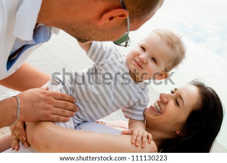 Happy young parents with child against the sea