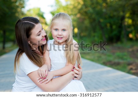 A girl with a baby in nature or in the park enjoy each other, and feel good