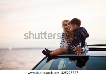 Beautiful woman with a child of four years in the car are going to have a trip