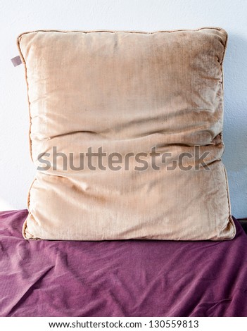 Brown scatter cushion on the purple cloth of living room.