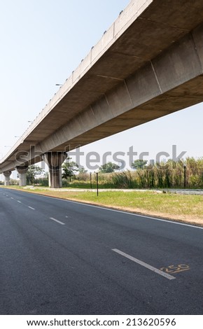 Empty asphalt road under the express way bridge in Thailand.