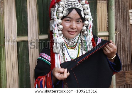 CHIANG RAI, THAILAND - OCT 1 : Akha woman with traditional clothes and silver jewelery in akha hitt tribe minority village on October 1, 2011 in Chiang Rai, Thailand.