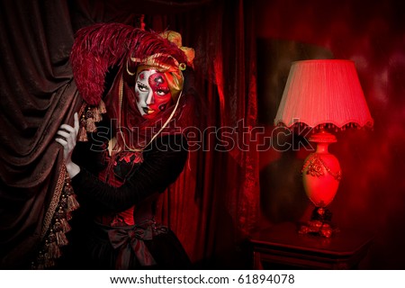 Beautiful girl with playing cards and cool Venetian mask makeup over vintage interior