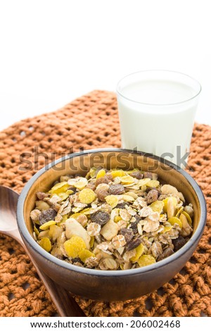 bran and raisin cereal in a bowl with glass of milk, top view