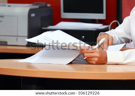 a worker man analyzing pile of paper
