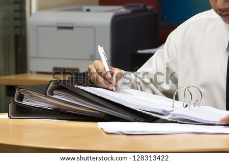 Businessman writing paper in file , hard work to do