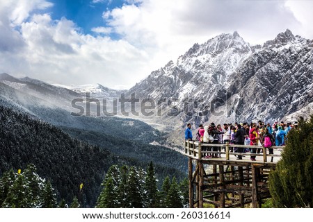 HUANGLONG, CHINA - OCTOBER 20, 2014 : Tourist visit the Huanglong scenic area while snowing on October 20, 2014 in Huanglong, Sichuan, China.