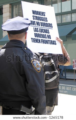 Workers demonstrate in Manhattan as policeman watches, 4/19/06