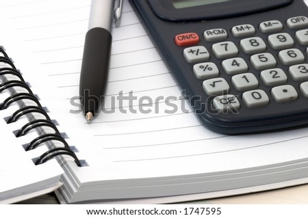 Note pad with pen and calculator on it.Closeup.