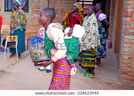 August 2014 - Pomerini - Tanzania - Africa - An African woman with her baby in traditional band, followed by the non-profit organization Mawaki to Fight AIDS, in the Franciscan Mission of Pomerini