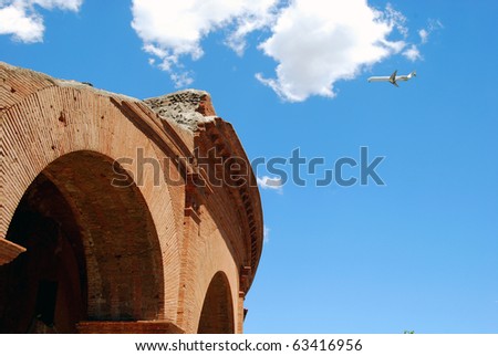 Between ancient and modern: the ruins of an ancient roman palace and an airplane in the blue sky