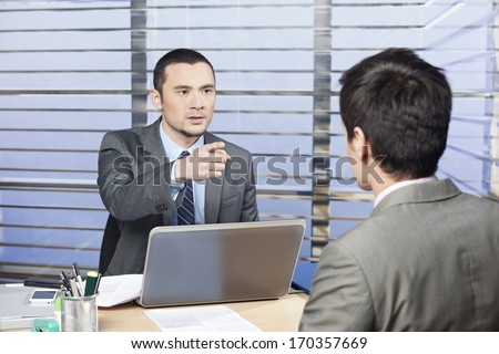 Young executive in the office criticize the performance of one of his team member - concept