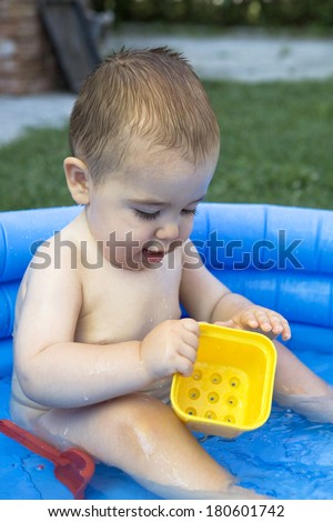 Baby boy playing in kiddie pool