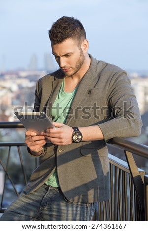 Portrait of a handsome man checking emails on his tablet pc