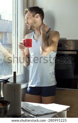 Handsome man drinking coffee by the window in the morning