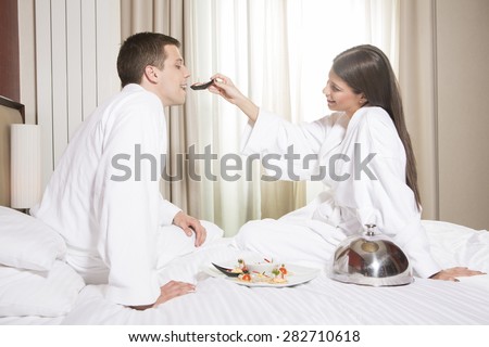 Young happy couple having breakfast in luxury hotel room.