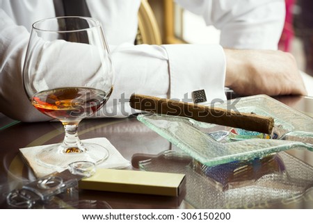 Luxury life, hedonism concept, cognac,cigar on wooden table