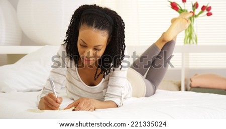 Young black woman writing in journal