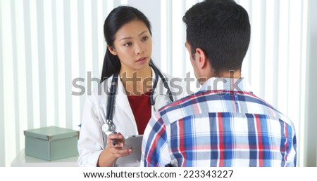 Asian doctor asking patient questions and taking notes