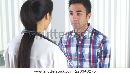 Chinese doctor listening to patient\'s heart