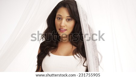 Sweet Mexican woman standing behind curtain