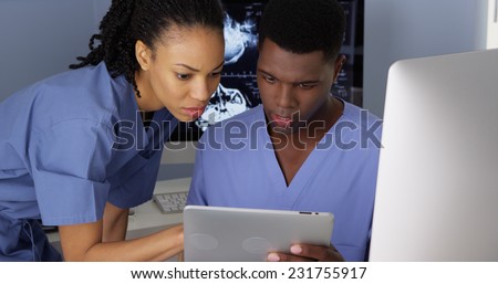 Two African American Medical specialists using computer and tablet