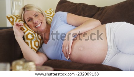 Beautiful pregnant woman lying on couch