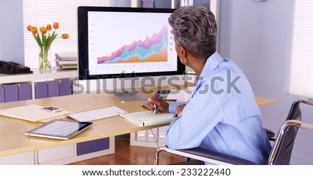 Handicapped black businesswoman working at desk