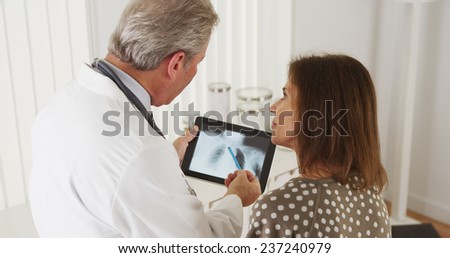 Doctor talking to elderly woman patient about xrays