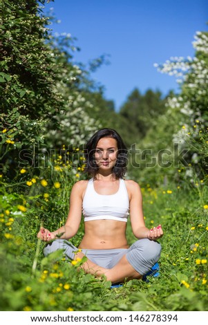 girl doing yoga outdoor looking in camera, vertical
