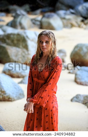 Blonde Woman in Red Wet Dress Posing at the beach